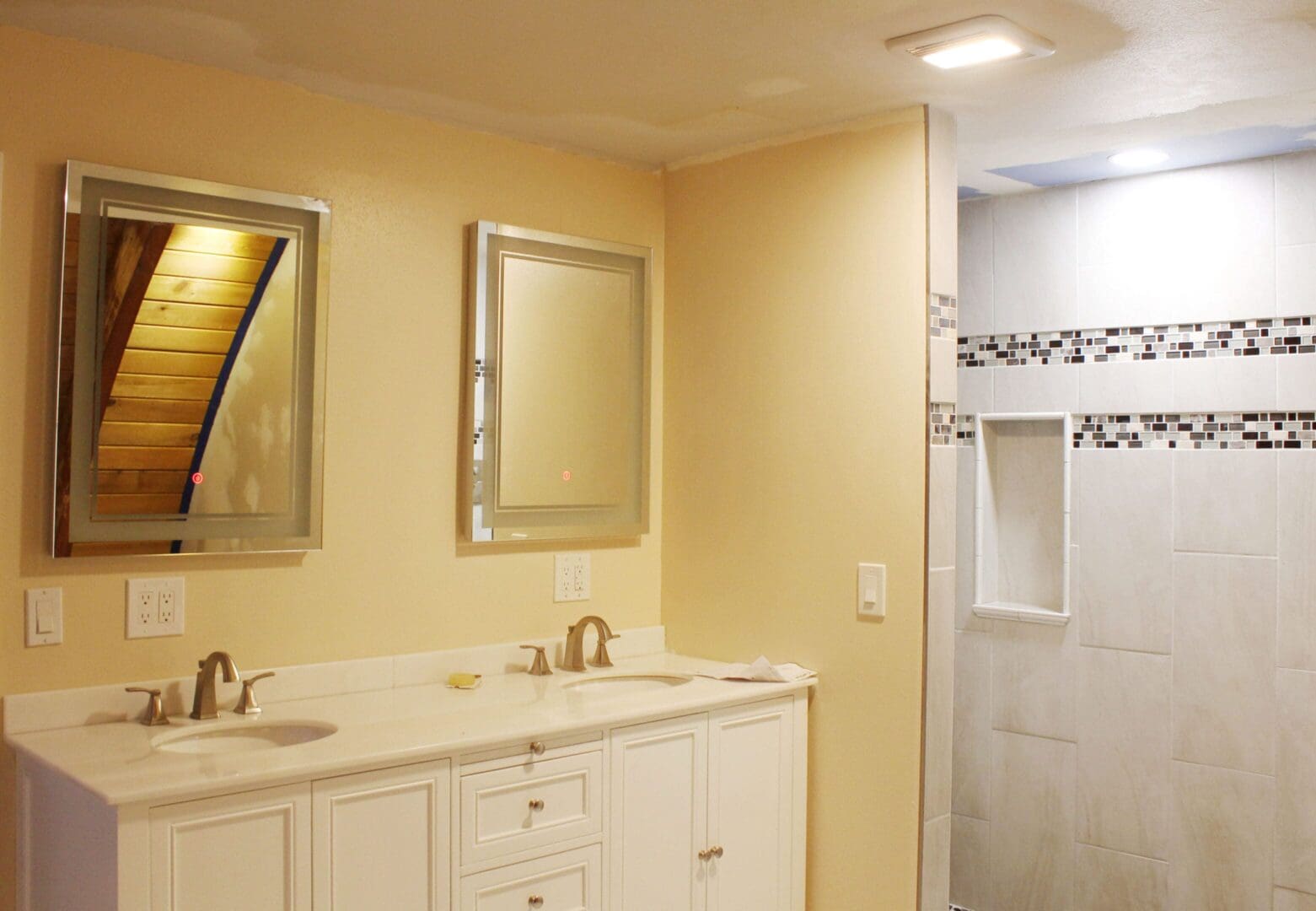 A bathroom with two sinks and a shower.
