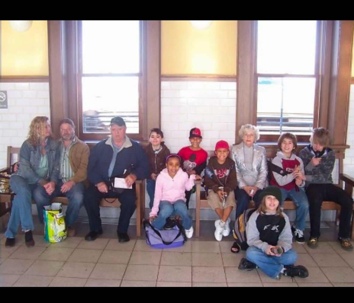 A group of people sitting in front of windows.